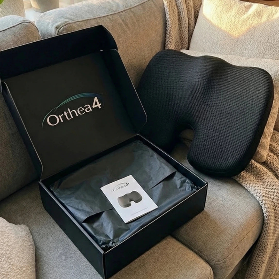 Black Orthea4 cushion on a beige couch with packaging