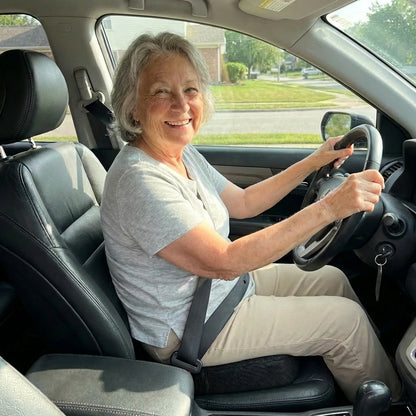 Woman sitting in a car, smiling at the camera
